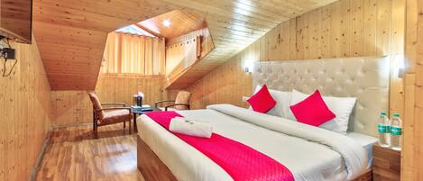 Una habitación de madera con una cama, una silla y una mesa.