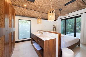 Une salle de bain moderne avec un meuble-lavabo en bois, une grande fenêtre et un ventilateur de plafond.