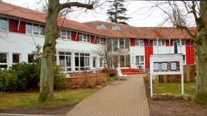 A building with a red-tiled roof, a white facade, and a sign reading "HAUS LINDEN". - Hotel Haus Linden (Ostseebad Prerow)