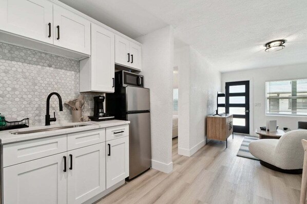 Enjoy cooking in this well-equipped kitchen with sleek cabinetry, a refrigerator, and microwave.