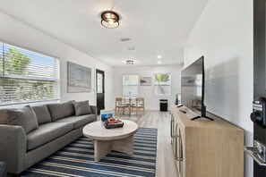Relax in this cozy living space with a comfortable sofa, flat-screen TV, and dining area.