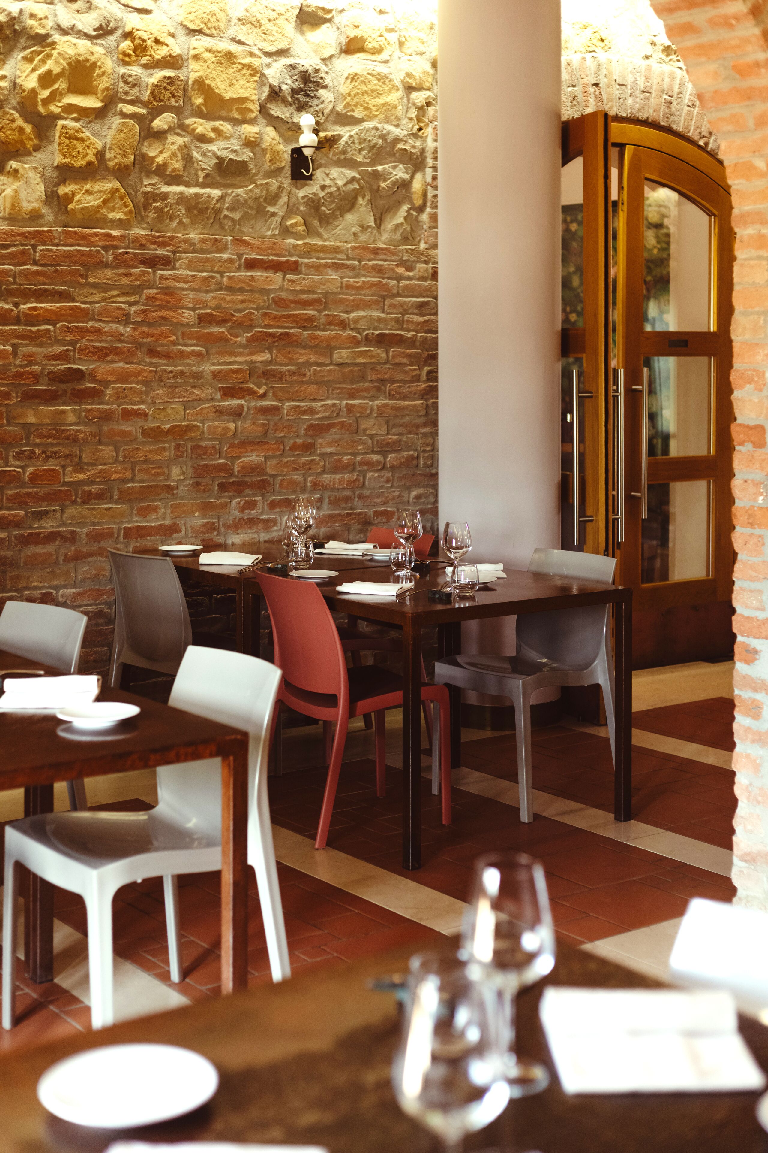 Un restaurant aux murs de briques, aux tables et aux chaises en bois.