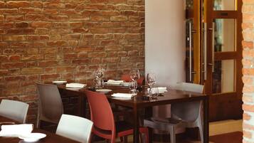 Un restaurant aux murs de briques, aux tables et aux chaises en bois.