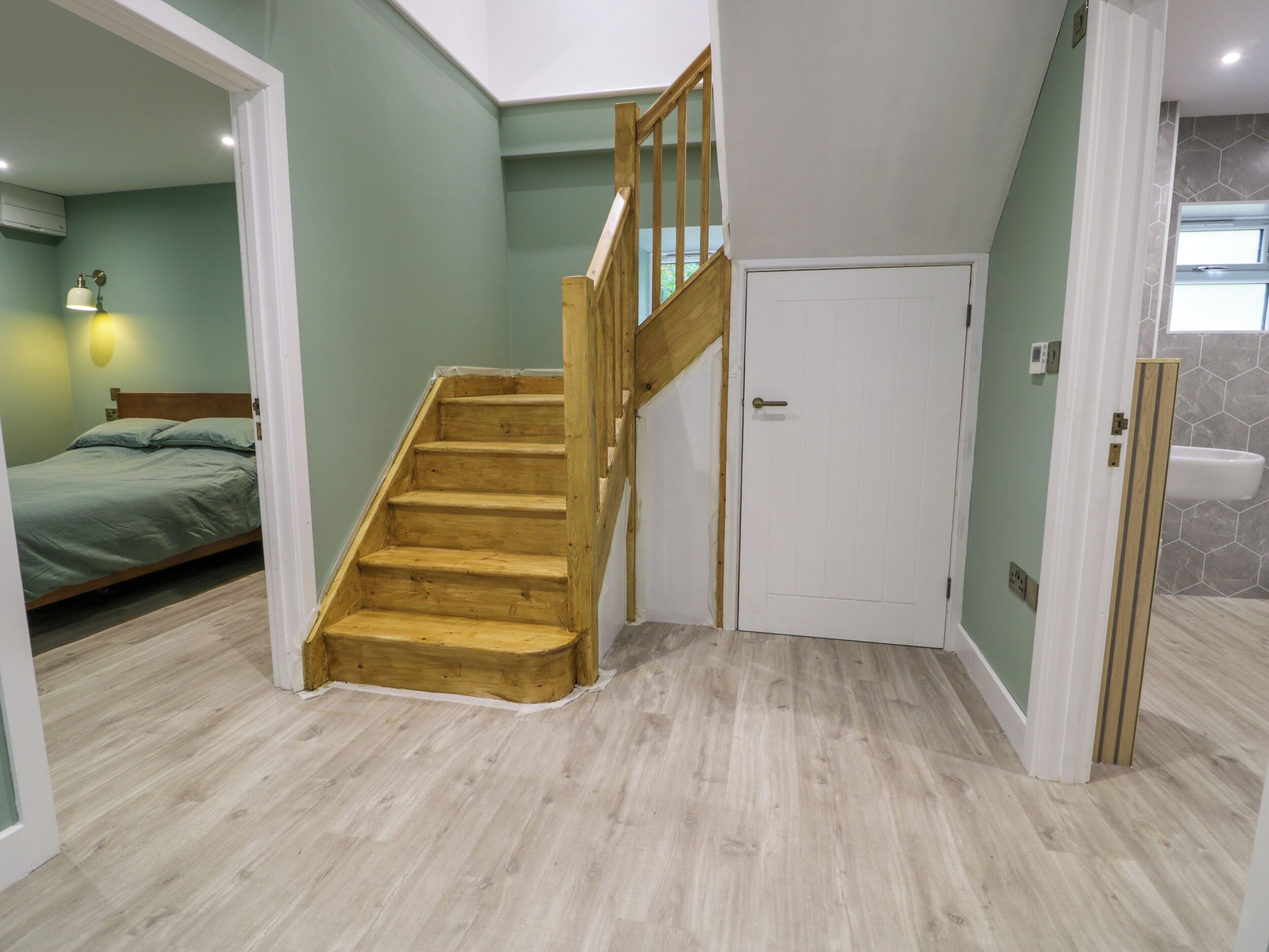 A staircase with wooden steps and a white door at the top.