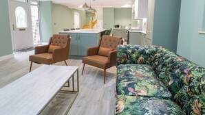 Una sala de estar moderna con un sofá, dos sillones y una mesa de centro.