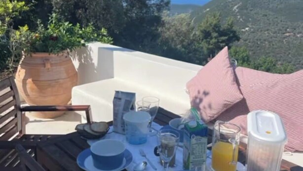 Una mesa lista para el desayuno con vistas a las colinas.