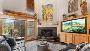 A living room with a fireplace, a large TV, and a sofa.