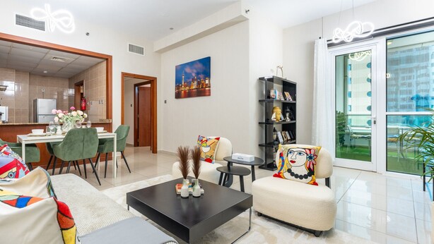 Un salon moderne comprenant un canapé, une table basse et un coin repas avec des chaises et une table.