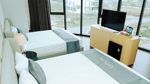 Une chambre d’hôtel avec deux lits, une télévision, un minibar et une vue sur l’extérieur.