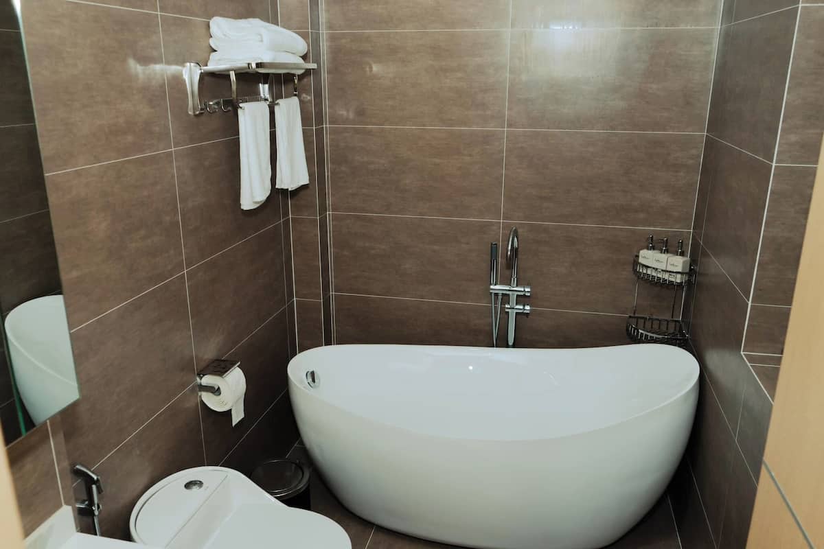 A modern bathroom with a freestanding bathtub, a toilet, and a sink.