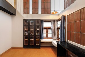 A room with a built-in bench, a wooden cabinet with glass doors, and a black countertop. - Terrastone Duplex Apartment (Bengaluru)