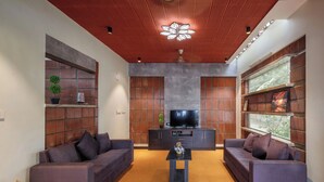 A modern living room with two sofas, a coffee table, and a TV on a wooden cabinet.