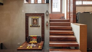 A multi-level interior with wooden staircases, a central staircase, and a decorative altar at the bottom.
