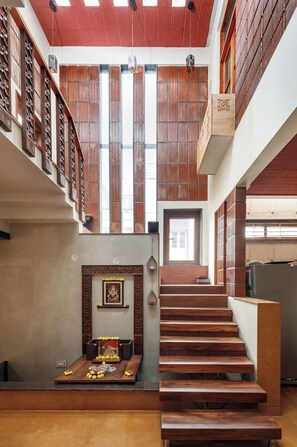 A multi-level interior with wooden staircases, a central staircase, and a decorative altar at the bottom.