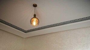A bedroom with a large bed, a wardrobe, and a hanging light fixture. - villa ssekan (Oulad Hassoune)