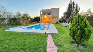 A modern two-story house with a swimming pool, a well-maintained lawn, and a few trees. - villa ssekan (Oulad Hassoune)
