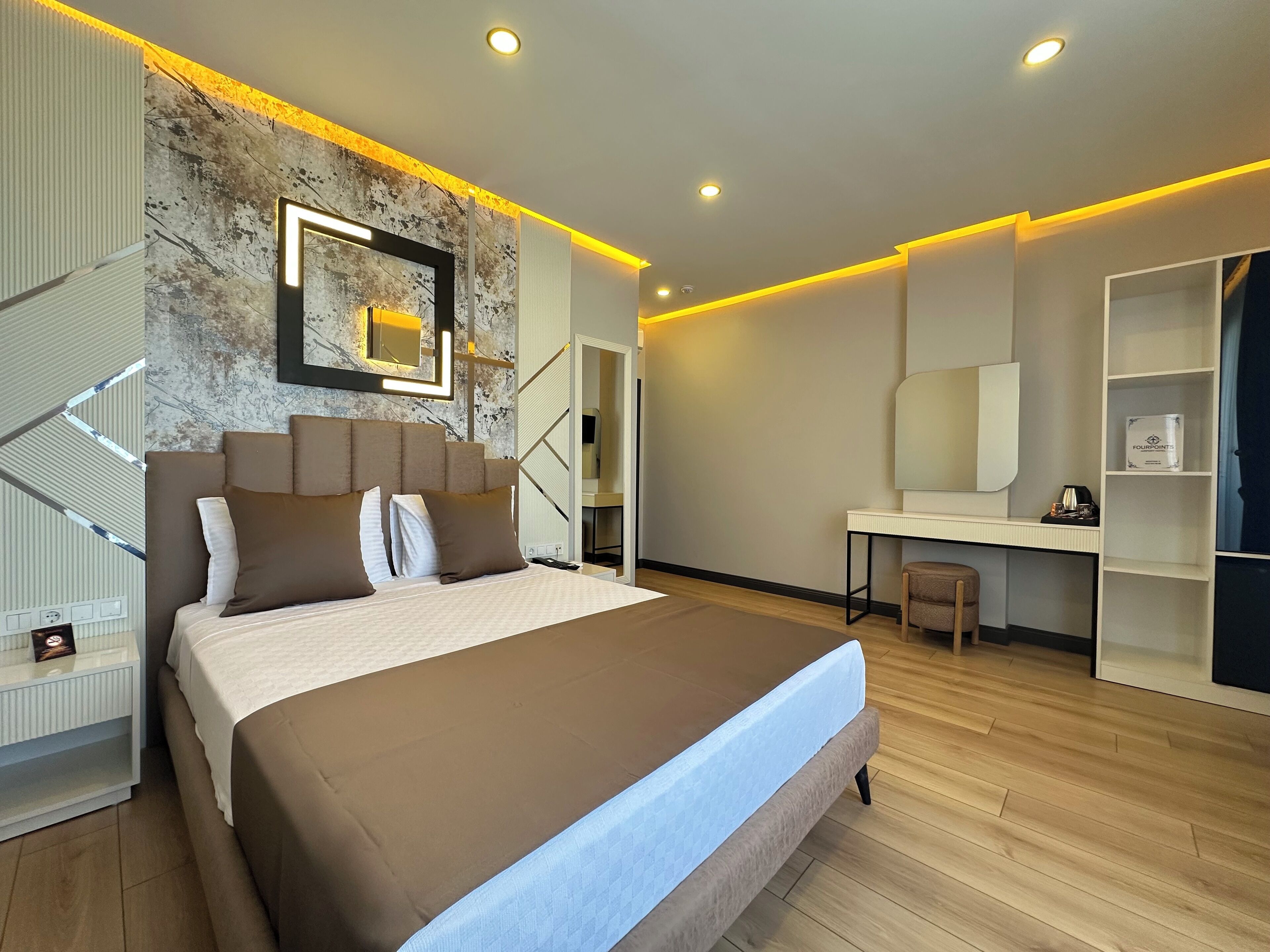 A modern bedroom with a large bed, a desk, and a walk-in closet.