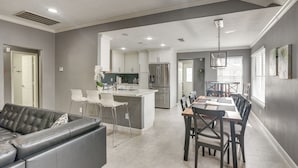 A modern kitchen with white cabinets, a central island, and stainless steel appliances. - 11 Mi to Dtwn: Family Home in Houston! (Houston)