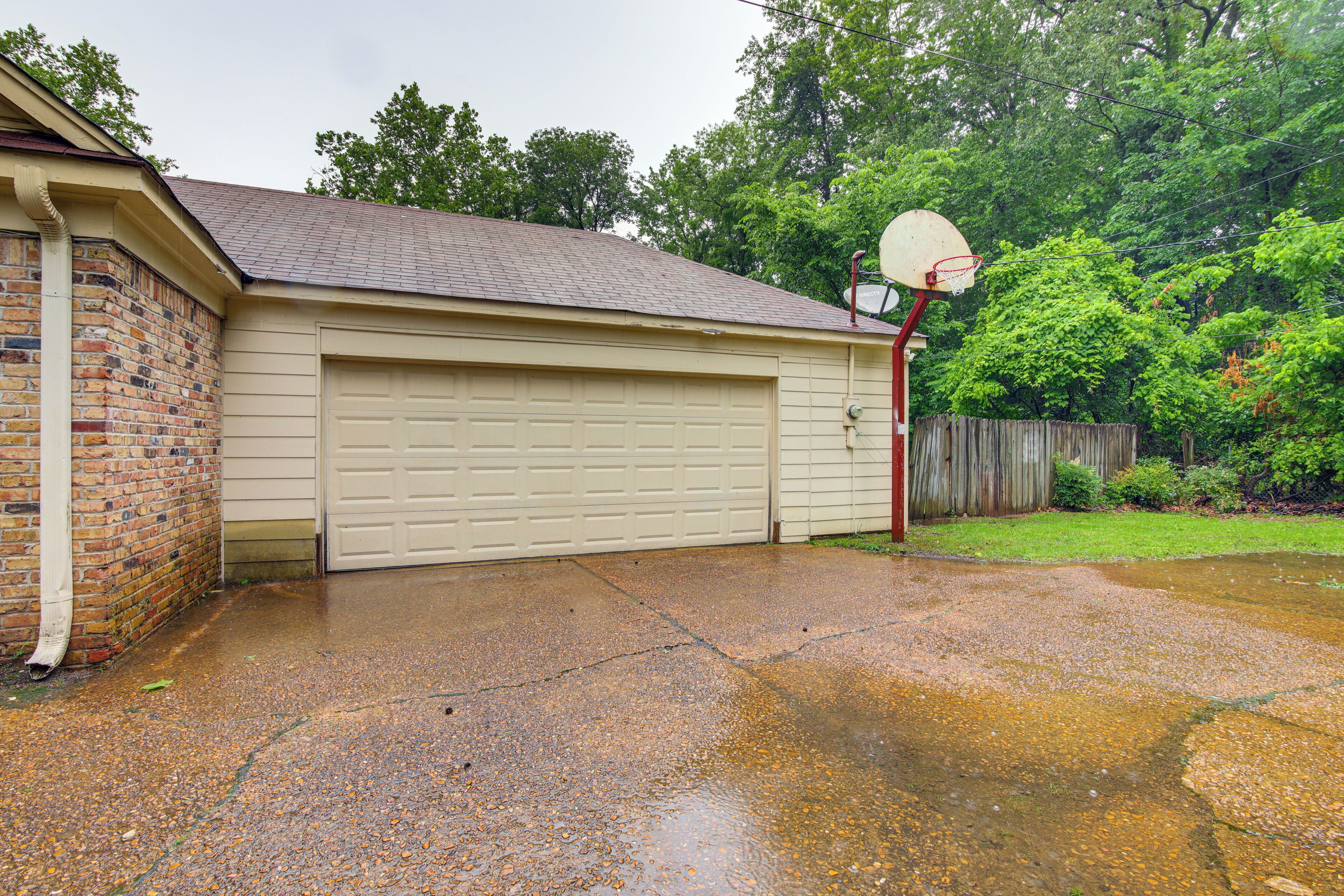 A residential garage with a brick exterior and a white garage door.