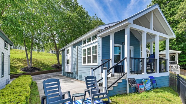 A house with a porch, outdoor seating, and a staircase leading to a covered area.