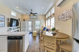 Una cocina moderna con lavavajillas, ventilador de techo y comedor con mesa y sillas.