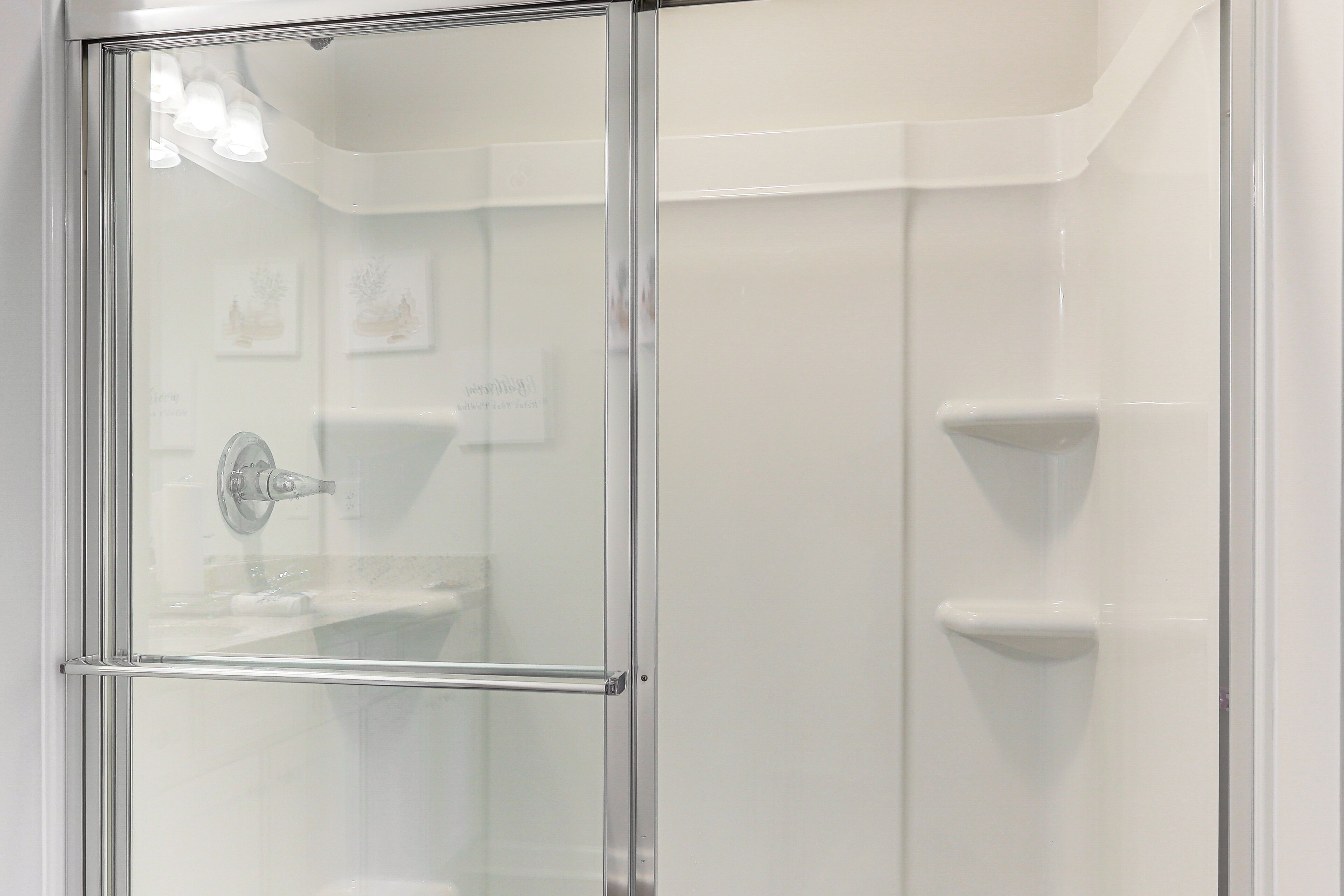 A modern bathroom with a glass shower enclosure, a visible toilet, and a sink.