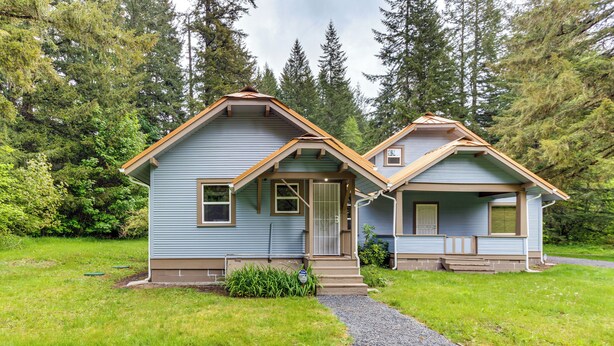 A two-story house with a front porch, a small front yard, and a gravel driveway. - Mt Rainier Retreat 7 Mi to Park Entrance! (Ashford)