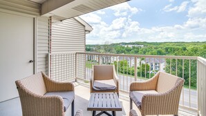 A balcony with wicker furniture and a view of a green landscape. - 1 Mi to 76 Strip: Family Condo in Branson! (Branson)