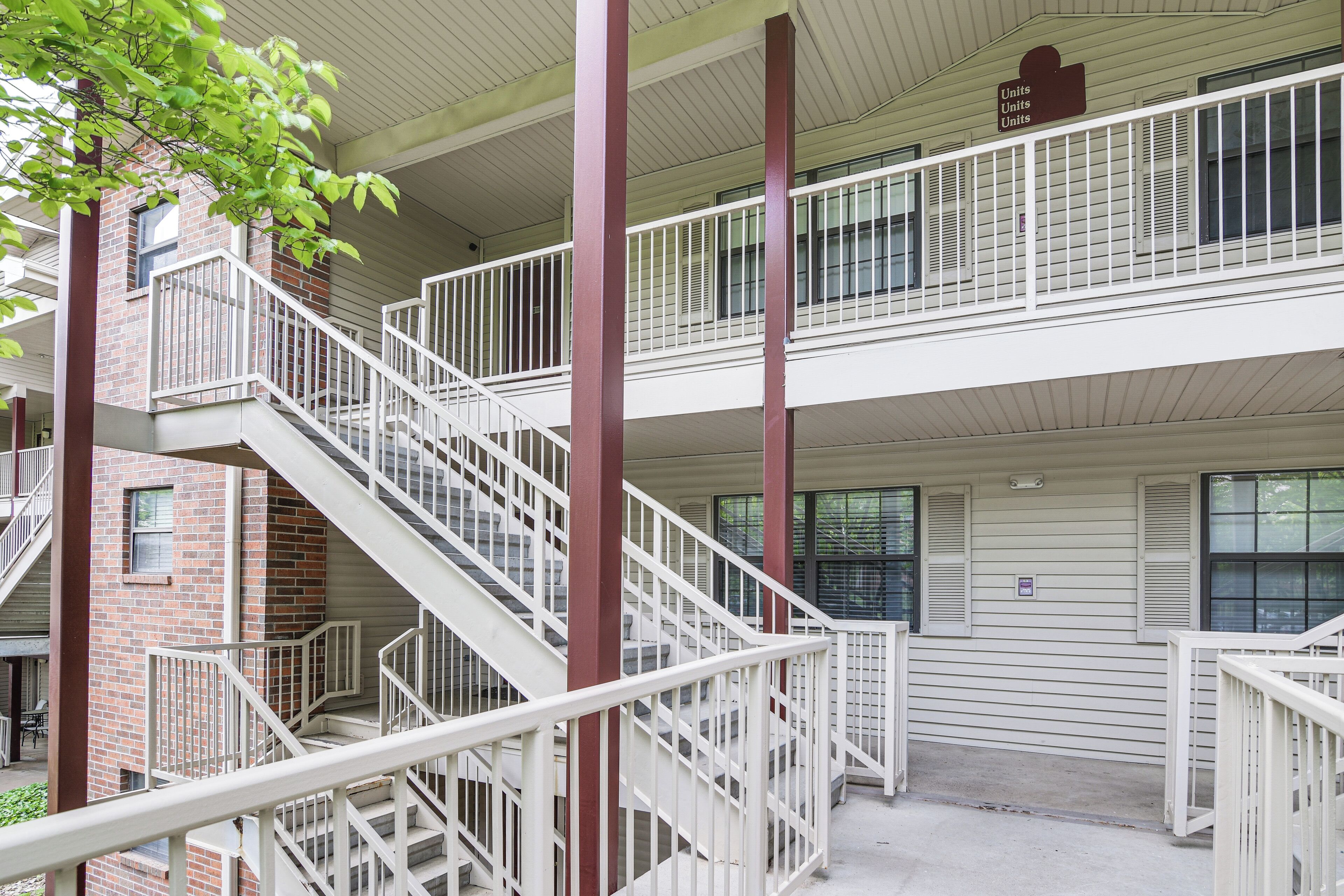A multi-level building with a central staircase, balconies, and a brick facade.