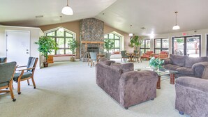 A spacious lobby with a stone fireplace, comfortable seating, and large windows. - 1 Mi to 76 Strip: Family Condo in Branson! (Branson)