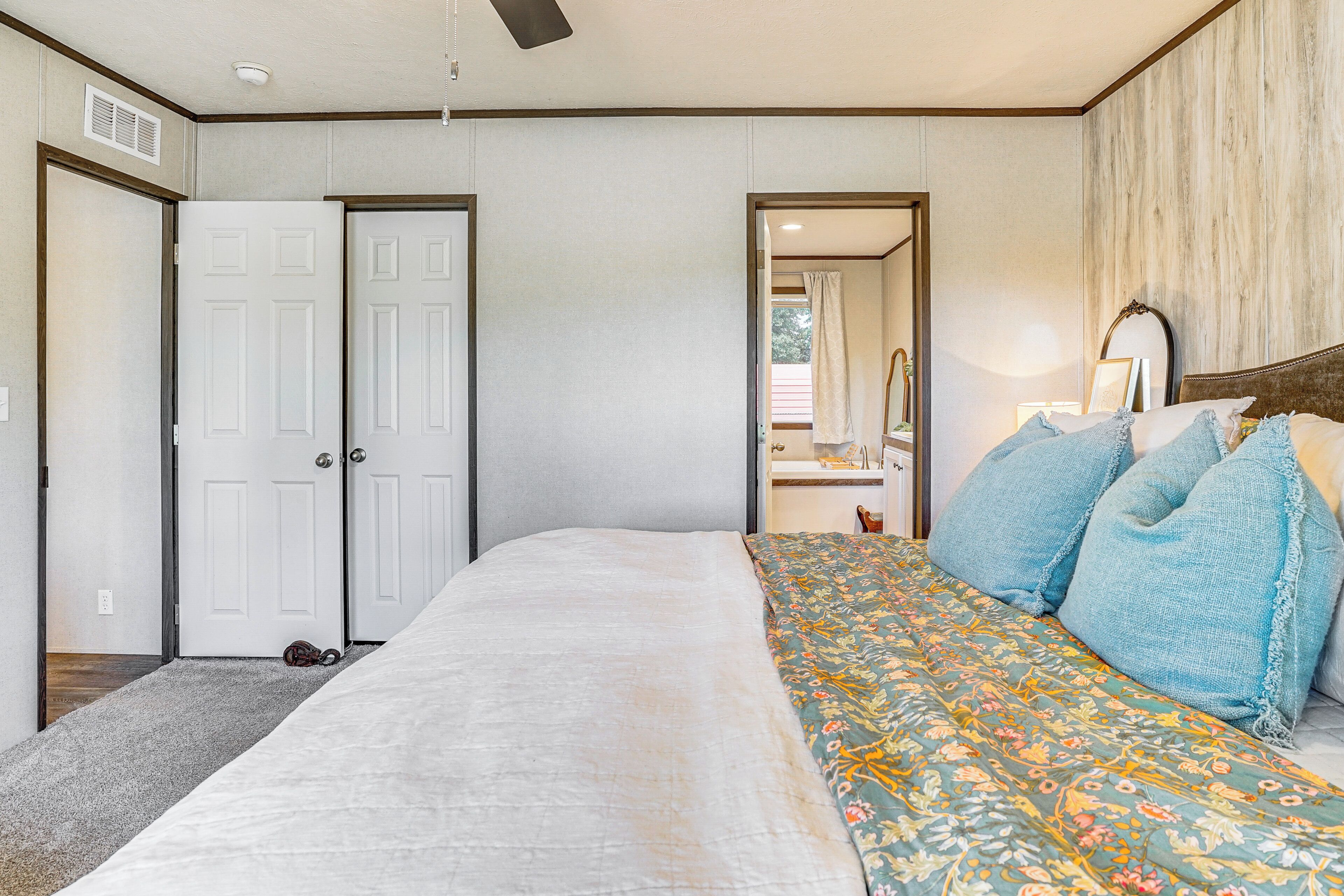 A bedroom with a bed, a dresser, and a mirror.