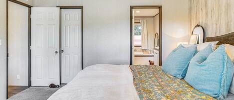 A bedroom with a bed, a dresser, and a mirror.