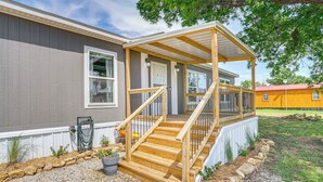 A house with a wooden deck, a stone pathway, and a small garden area. - 12 Mi to Possum Kingdom Lake: Graford Getaway! (Graford)