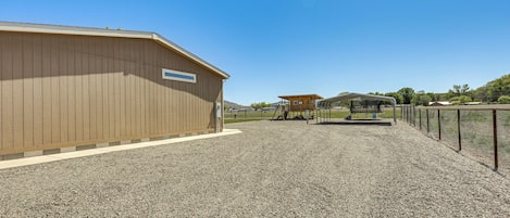 A gravel driveway leading to a building with a wooden exterior.