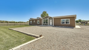 A two-story building with a gravel driveway and a grassy lawn. - 10 Mi to Aztec Ruins: Family Home w/ Large Yard! (Aztec)