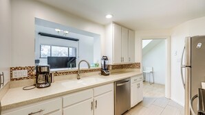 A modern kitchen with white cabinets, a stainless steel dishwasher, and a coffee maker. - Pool & Trail Access On-site: Modern Austin Condo! (Austin)