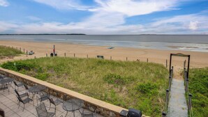 A beach view with a paved walkway leading to a sign reading "Welcome & Welcome". - Beachfront Unit 17 Fall Escape by the Ocean! (Old Orchard Beach)