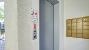 Seinässä on paloturvallisuutta koskeva opaste, ovi ja rivi postilaatikkoja.