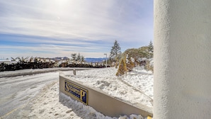 A snow-covered parking area with a sign for 'SUGARTOP'. - Sugartop Resort Condo: Grandfather Mountain Views! (Banner Elk)