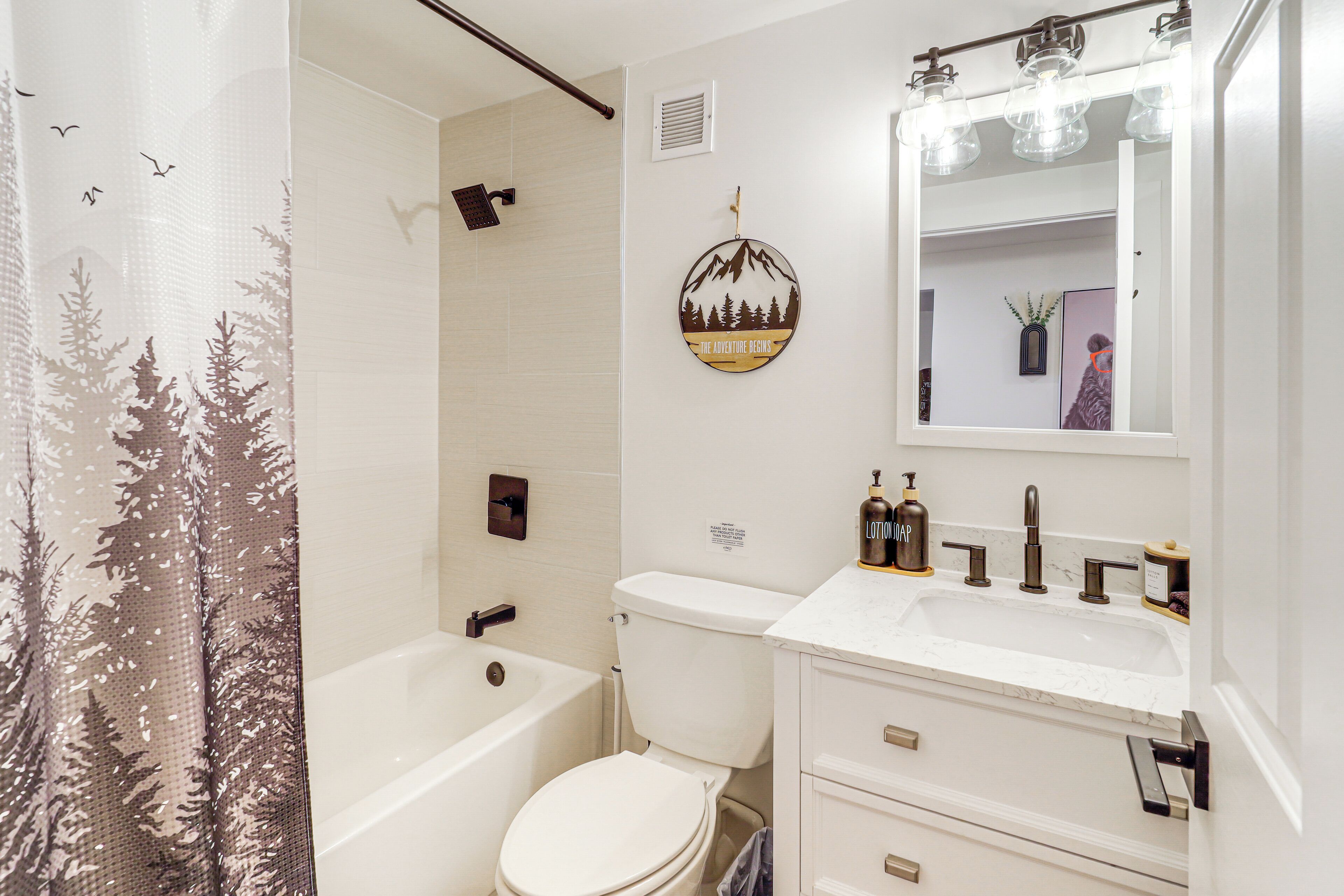 A bathroom with a bathtub, toilet, and sink.