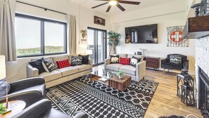 A modern living room with a sofa, coffee table, and a fireplace. - Sugartop Resort Condo: Grandfather Mountain Views! (Banner Elk)