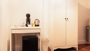 Une petite cuisine équipée d’une machine à café, d’une bouilloire et d’un réfrigérateur.