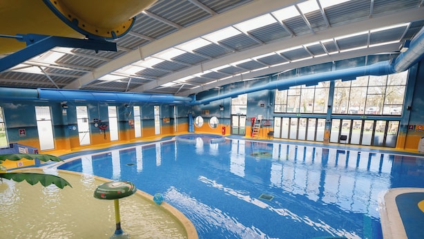 Une piscine intérieure à l’eau claire, dotée d’un plongeoir et d’un poste de surveillance pour le sauveteur.