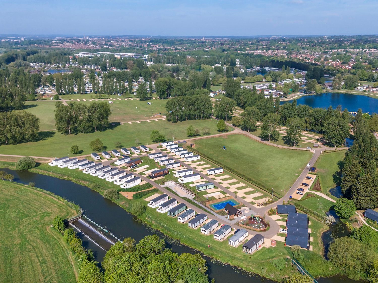 A large RV park with multiple rows of RVs and a central grassy area.