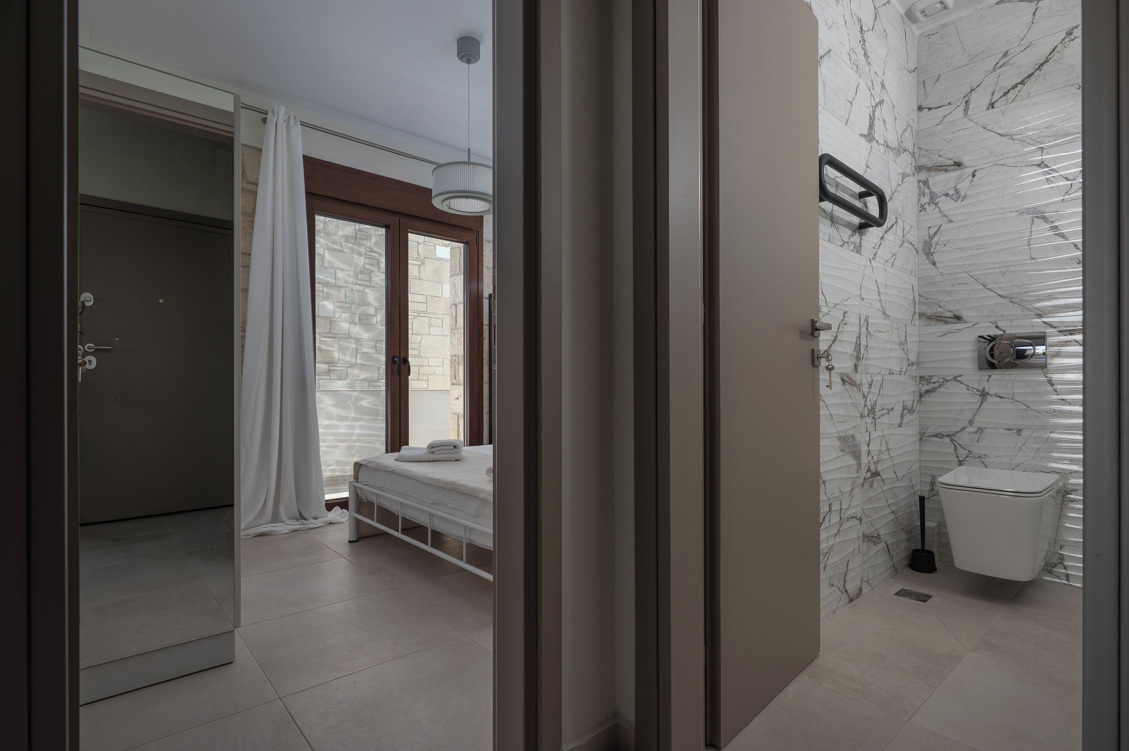A modern bathroom with a toilet, bidet, and shower area.