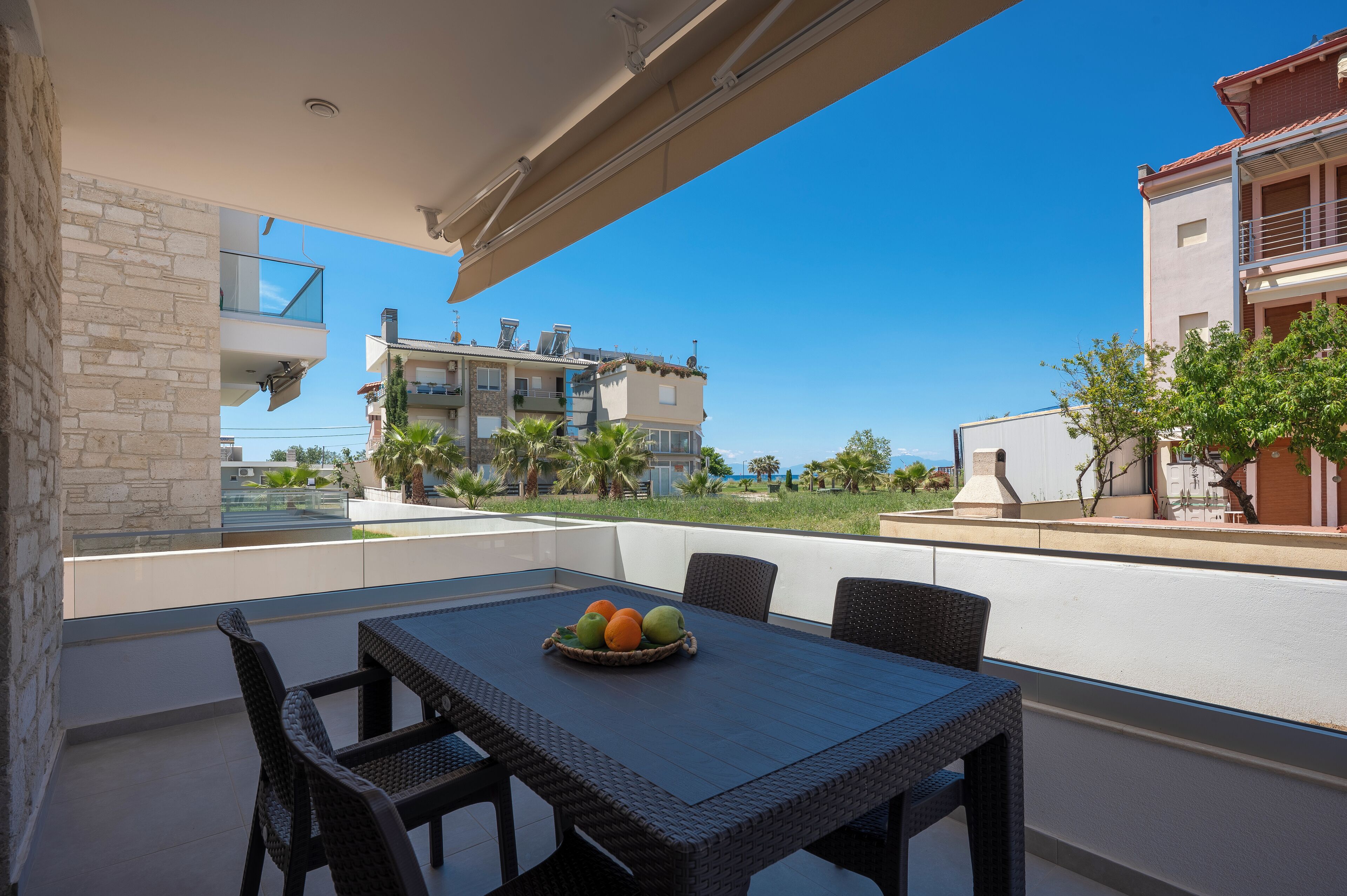 A balcony with wicker furniture and a fruit bowl.
