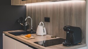A modern kitchen with a wooden countertop, a kettle, a coffee maker, and a cutting board with an orange. - Horizonte Rogowo Klimatyzacja Blisko pla y i Jeziora (Trzebiatow)