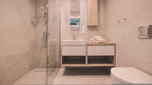 A modern bathroom with a glass shower enclosure, a white sink, and a wooden vanity. - Horizonte Rogowo Klimatyzacja Blisko pla y i Jeziora (Trzebiatow)