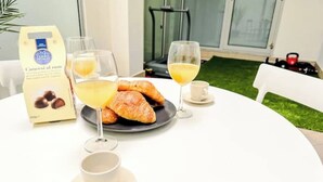 Un desayuno con cruasanes, zumo de naranja y café en una mesa.