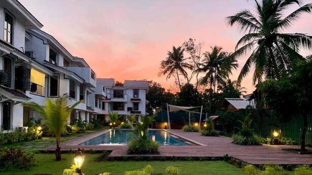 A modern hotel with a swimming pool, well-maintained gardens, and palm trees. - Cozy 1BR Apt in Siolim 3km to Uddo Beach (Siolim)